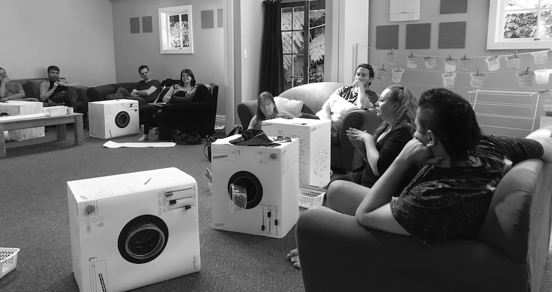 A luandromat in action: a group of people with cardboard washing machines discuss their projects
