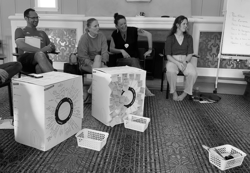 A group of people sit around with their laundromat washing machines at an EI laundromat